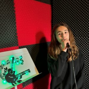 Jeune fille qui chante assise avec un micro